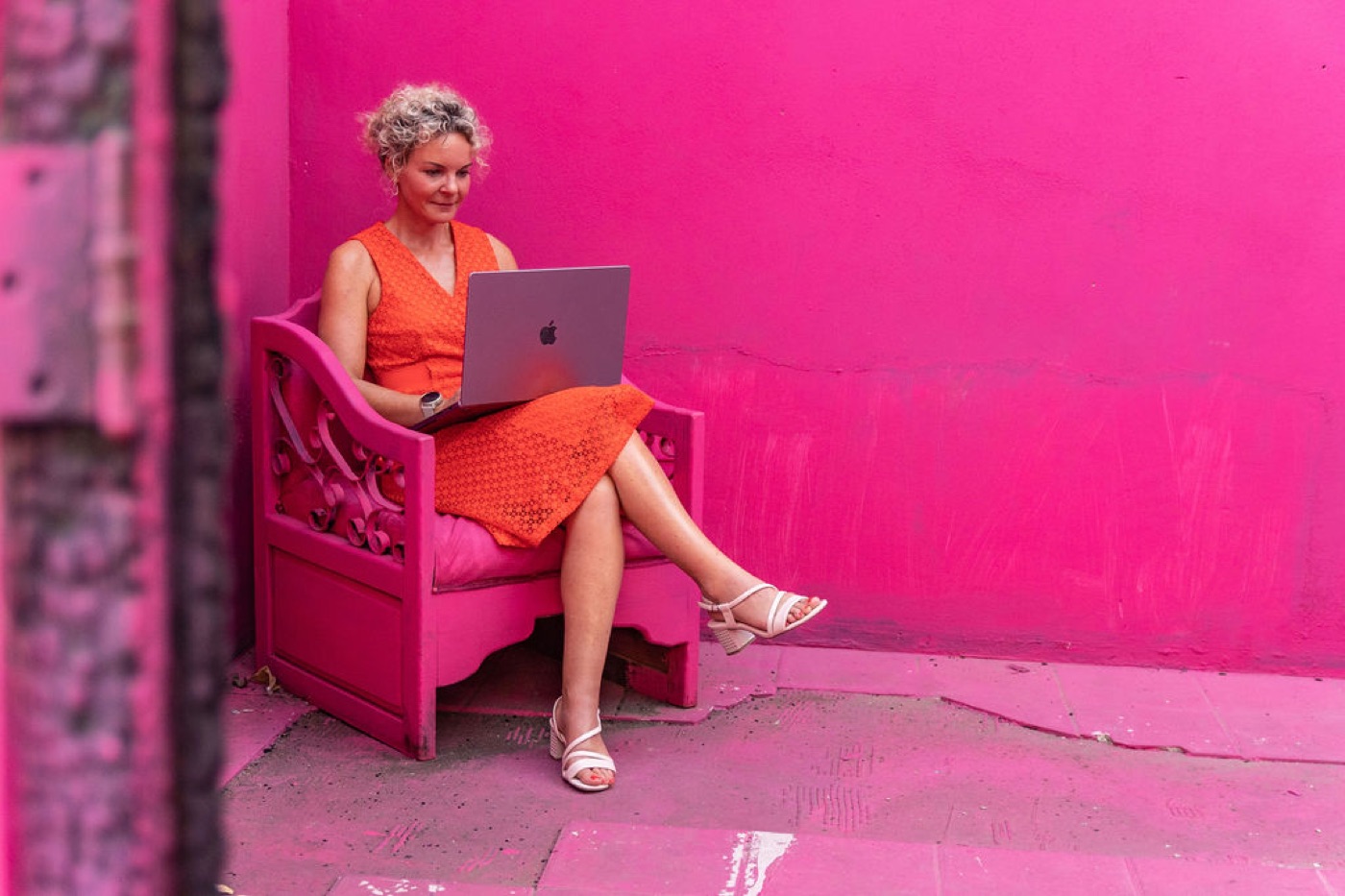 Daisy Kuipers werkt online met haar laptop in een roze stoel
